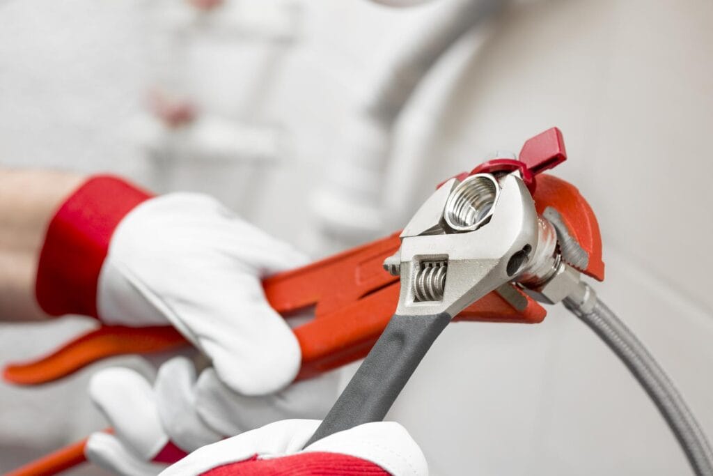 Plumber holding pipe wrenches for an emergency repair in Hollywood