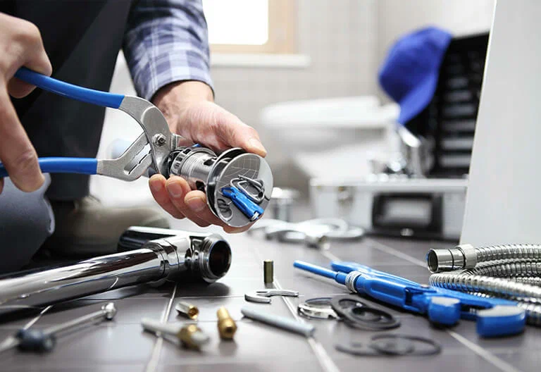 Technician repairing a plumbing fixture with professional tools in Hollywood