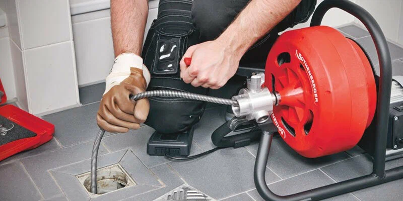 Plumber using a drain-cleaning machine in Hollywood