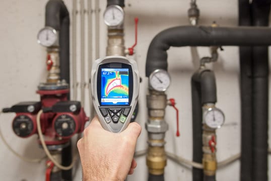 Plumber using a thermal imaging camera to inspect pipes in Hollywood