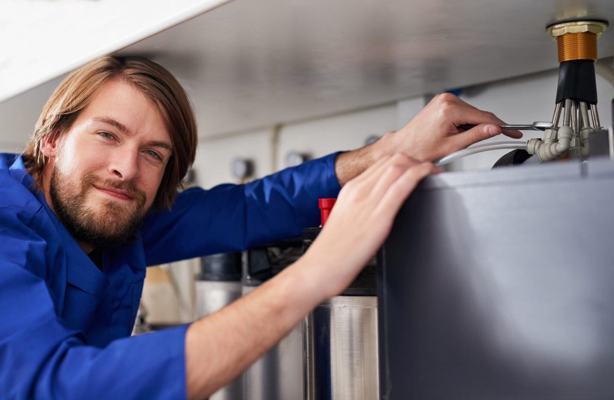 Technician servicing a residential water heater tank in Hollywood