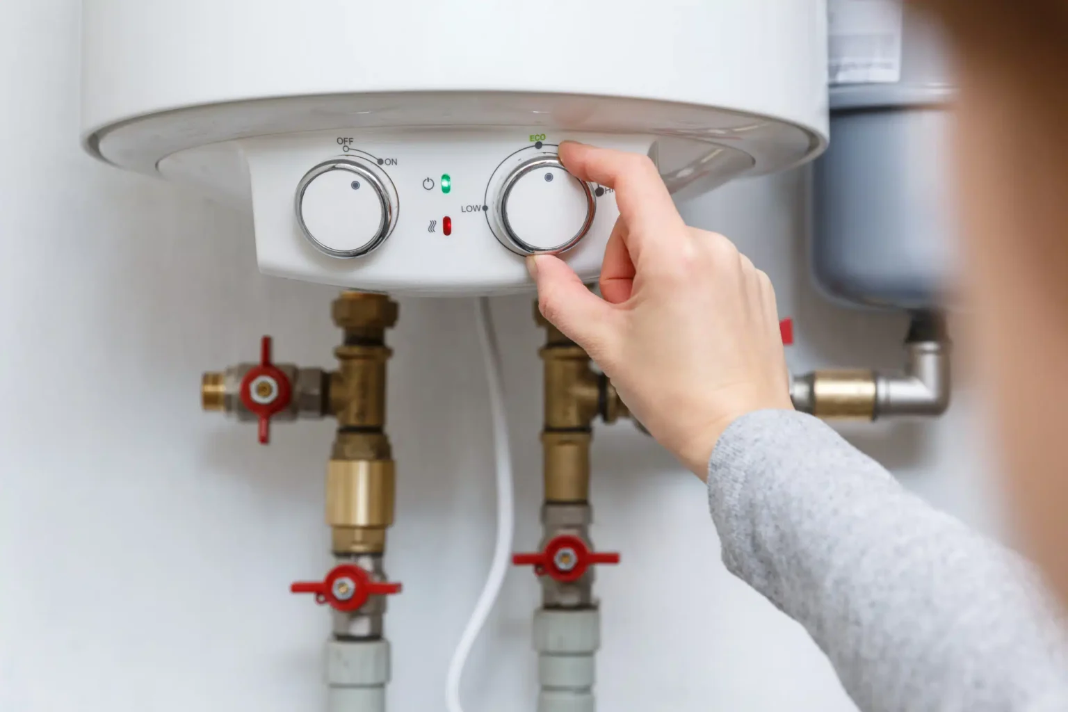 Homeowner adjusting the temperature controls on a water heater in Hollywood